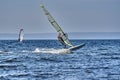 A male athlete is interested in windsurfing. He moves on a Sailboard on a large lake Royalty Free Stock Photo