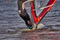 A male athlete is interested in windsurfing. He moves on a Sailboard on a large lake Royalty Free Stock Photo