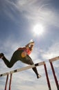 Male Athlete Jumping Hurdle