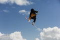 Male athlete jumping with snowboard high against a blue sky and white clouds Royalty Free Stock Photo