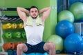 Male athlete kneeling down by dumbbells toweling sweat of his brow. Royalty Free Stock Photo
