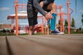 Male athlete legs on a sports field, sportsman taking a bottle with water , rehydrating his body during workout outdoor. Close-up Royalty Free Stock Photo