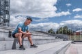 Male athlete listens music on phone, reads writes message, online app on Internet, free space text motivation. In summer Royalty Free Stock Photo