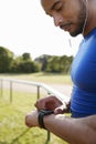 Male athlete at running track setting smartwatch app