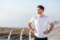 Male athlete standing on pier near the sea Royalty Free Stock Photo