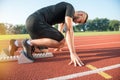 Male athlete on starting position at athletics running track. Royalty Free Stock Photo