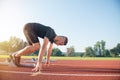 Male athlete on starting position at athletics running track. Royalty Free Stock Photo