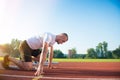 Male athlete on starting position at athletics running track. Royalty Free Stock Photo