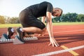 Male athlete on starting position at athletics running track. Royalty Free Stock Photo