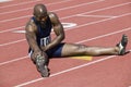 Male Athlete Stretching On Racetrack