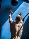 Male athlete throwing fit ball on wall in a gym Royalty Free Stock Photo