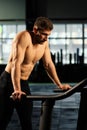 Male athlete tired after jogging on a treadmill, resting after sports