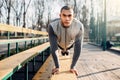 Male athlete warming up before run in autumn park