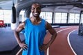 Male athletic standing with hands on hip in fitness center