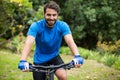 Male athletic standing with mountain bike in forest Royalty Free Stock Photo