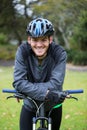 Male athletic standing with mountain bike in park