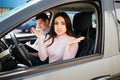 Male auto instructor takes exam in young woman. She sit on driver`s place and look on camera with confusion. Stressed Royalty Free Stock Photo