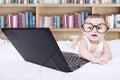 Male baby with laptop and a bookshelf background Royalty Free Stock Photo