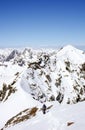 Backcountry skier hikes along narrow mountain ridge in the Swiss Alps
