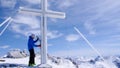 Male backcountry skier hiking to a high alpine summit in Switzerland along a rock and snow ridge in light fog