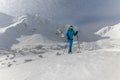 Male backcountry skier hiking to the summit of a snowy peak in the Low Tatras in Slovakia.