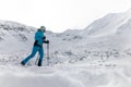 Male backcountry skier hiking to the summit of a snowy peak in the Low Tatras in Slovakia.