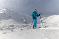 Male backcountry skier hiking to the summit of a snowy peak in the Low Tatras in Slovakia.