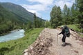 Male with a backpack standing on a trail near Kucherla River, Altai Mountains, Altai Republic, Russia