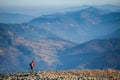 Male backpaker walking on the rocky top of the mountain