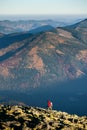 Male backpaker walking on the rocky top of the mountain