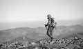 Male backpaker walking on the rocky top of the mountain