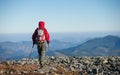 Male backpaker walking on the rocky top of the mountain