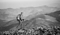 Male backpaker walking on the rocky top of the mountain