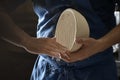 Male baker lightly flouring proofing basket for home made sourdough bread.