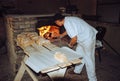 Male baker taking bread out of the oven in Wdzydze Kiszewskie, Poland