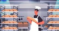 male baker in uniform holding bread bakery products baking manufacture concept portrait