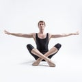 Male Ballerino Dancer Sitting While Practising Legs and Arms Stretching Exercices In Black Sportive Tights in Studio