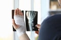 Male bandaged hand holds xray image closeup