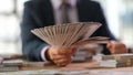 Male banker holding fan of dollar banknotes closeup