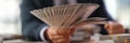 Male banker holding fan of dollar banknotes closeup