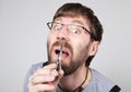 Male barber cuts his own hair in the nose, looking at the camera like the mirror. stylish professional hairdresser Royalty Free Stock Photo