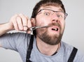 Male barber cuts his own mustache, looking at the camera like the mirror. stylish professional hairdresser expresses Royalty Free Stock Photo