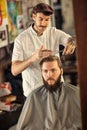 Male barber giving client haircut Royalty Free Stock Photo