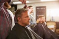 Male Barber Giving Client Haircut In Shop