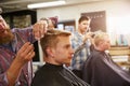 Male Barber Giving Client Haircut In Shop