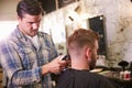 Male Barber Giving Client Haircut In Shop