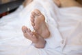 Male Bare Feet In A Bed On White Linen, Selected Focus