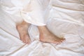 Male Bare Feet In A Bed On White Linen, Selected Focus