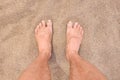 Male bare feet on hot beach sand closeup Royalty Free Stock Photo