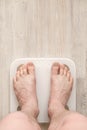 Male bare feet stand on smart scales that makes bioelectric impedance analysis, BIA, body fat measurement. Copy space. Royalty Free Stock Photo